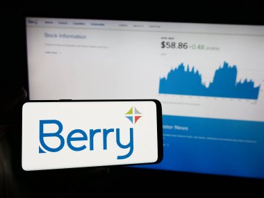 Stuttgart, Almanya - 05-06-2024: İnternet sayfası önünde üzerinde Amerikan plastik ambalaj şirketi Berry Global Group Inc. 'in logosu bulunan cep telefonu sahibi kişi. Telefon ekranına odaklan.