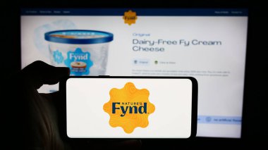 Stuttgart, Almanya - 05-14-2024: ABD 'li şirket The Fynder Group Inc. (Doğa Fynd)' in web sayfası ile logo önünde cep telefonu bulunduran kişi. Telefon ekranının merkezine odaklan.
