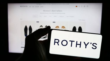 Stuttgart, Almanya - 05-14-2024: İnternet sitesinin önünde ABD 'li ayakkabı ve aksesuar şirketi Rothy' nin logosuna sahip akıllı telefon sahibi kişi. Telefon ekranına odaklan.