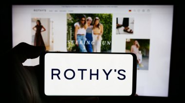 Stuttgart, Almanya - 05-14-2024: Üzerinde ABD 'li ayakkabı ve aksesuar şirketi Rothys Inc.' in logosu bulunan cep telefonu sahibi kişi iş sayfasının önünde. Telefon ekranına odaklan.