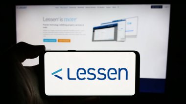 Stuttgart, Almanya - 05-14-2024: ABD 'li emlak hizmetleri pazar yeri şirketi Lessen Inc.' in logosuyla cep telefonu sahibi kişi iş sayfasının önünde. Telefon ekranına odaklan.