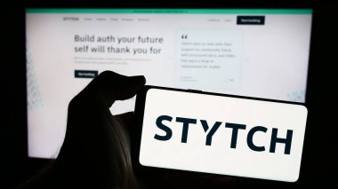 Stuttgart, Almanya - 05-14-2024: Üzerinde Amerikan kimlik platformu şirketi Stytch Inc. 'in logosu bulunan cep telefonu sahibi kişi iş sayfasının önünde. Telefon ekranına odaklan.