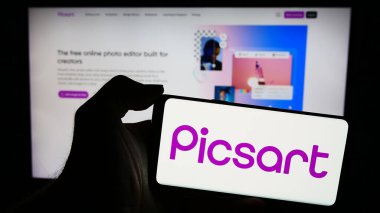 Stuttgart, Almanya - 05-16-2024: İnternet sayfasının önünde Amerikan yapay zeka platformu şirketi PicsArt Inc. 'in logosu olan cep telefonu sahibi kişi. Telefon ekranına odaklan.