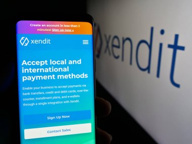 Stuttgart, Almanya - 05-16-2024: Endonezyalı PT Sinar Digital Terdepan (Xendit) şirketinin internet sayfası ile cep telefonu tutan kişi. Telefon ekranının merkezine odaklan.