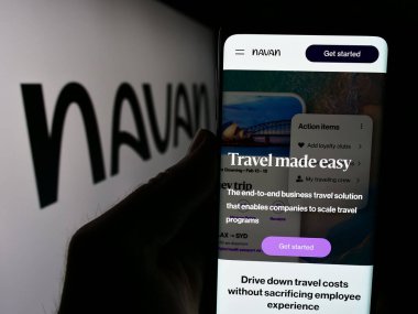 Stuttgart, Almanya - 05-17-2024: ABD seyahat yönetimi yazılım şirketi Navan Inc. 'in web sayfası ile logo önünde cep telefonu tutan kişi. Telefon ekranının merkezine odaklan.