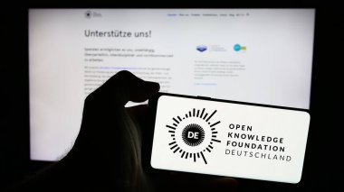 Stuttgart, Almanya - 05-21-2024: Açık Bilgi Vakfı Deutschland E.V. logosu olan kişi (OKFDE) Web sayfasının önünde. Telefon ekranına odaklan.