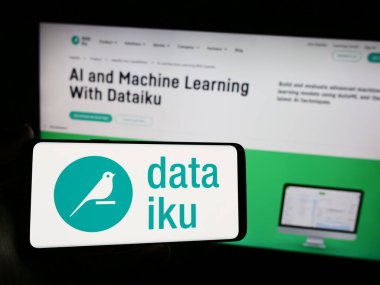 Stuttgart, Almanya - 05-21-2024: İnternet sitesi önünde üzerinde ABD Yapay Zeka (AI) şirketi Dataiku Inc. 'in logosu bulunan akıllı telefon sahibi kişi. Telefon ekranına odaklan.