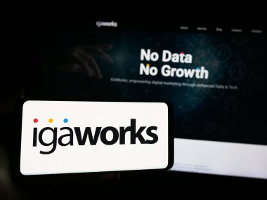 Stuttgart, Almanya - 05-15-2024: İnternet sitesi önünde Güney Koreli dijital pazarlama şirketi IGAWorks 'un logosuna sahip kişi. Telefon ekranına odaklan.