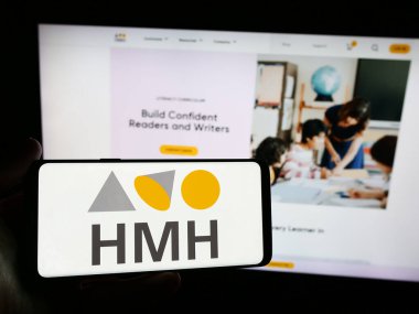 Stuttgart, Almanya - 05-22-2024: İnternet sitesi önünde üzerinde Houghton Mifflin Harcourt Yayıncılık Şirketi (HMH) logosu bulunan kişi. Telefon ekranına odaklan.