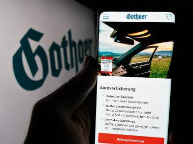 Stuttgart, Almanya - 05-22-2024: Alman sigorta şirketi Gothaer Versicherungsbank VVaG 'ın logolu web sayfası ile akıllı telefon tutan kişi. Telefon ekranının merkezine odaklan.