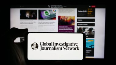 Stuttgart, Almanya - 05-23-2024: İnternet sayfası önünde Global Araştırmacı Gazetecilik Ağı (GIJN) logosu bulunan kişi. Telefon ekranına odaklan.