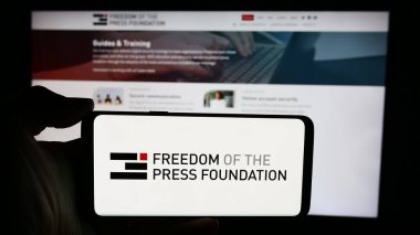 Stuttgart, Almanya - 05-23-2024: İnternet sayfası önünde üzerinde Basın Özgürlüğü Vakfı (FPF) organizasyonu logosu bulunan kişi. Telefon ekranına odaklan.