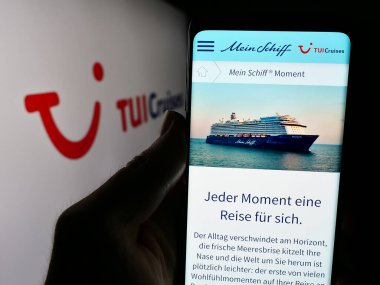 Stuttgart, Almanya - 05-23-2024: Alman seyir şirketi TUI Cruises GmbH (Mein Schiff) 'in logolu web sitesi ile cep telefonu tutan kişi. Telefon ekranının merkezine odaklan.