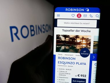 Stuttgart, Almanya - 05-23-2024: Alman konukseverlik şirketi Robinson Club GmbH 'nin web sitesi ile logo önünde cep telefonu tutan kişi. Telefon ekranının merkezine odaklan.