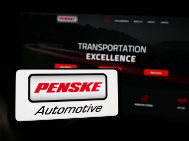 Stuttgart, Almanya - 05-23-2024: İnternet sitesi önünde ABD 'li otomotiv şirketi Penske Automotive Group Inc.' in logosuna sahip kişi. Telefon ekranına odaklan.