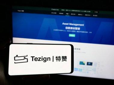 Stuttgart, Almanya - 05-15-2024: Çinli içerik analitik şirketi Tezign 'in logosunun bulunduğu akıllı telefonu web sitesinin önünde tutan kişi. Telefon ekranına odaklan.