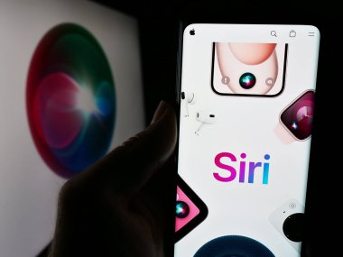 Stuttgart, Almanya - 05-24-2024: Logo önünde dijital yardımcı yazılım Siri (Apple Inc.) web sitesi olan akıllı telefon sahibi kişi. Telefon ekranının merkezine odaklan.