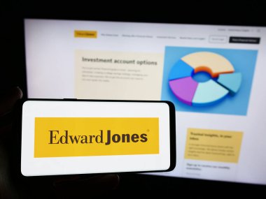 Stuttgart, Almanya - 05-27-2024: ABD 'li finans hizmetleri şirketi Edward Jones Investments' ın logosunun bulunduğu akıllı telefon sahibi kişi web sitesi önünde. Telefon ekranına odaklan.