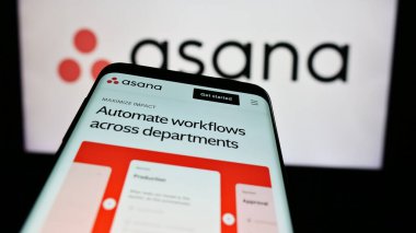 Stuttgart, Almanya - 05-27-2024: İş dünyası logosu önünde ABD 'li iş yönetimi yazılım şirketi Asana Inc.' in web sayfası ile cep telefonu. Telefon ekranının sol üst kısmına odaklan.