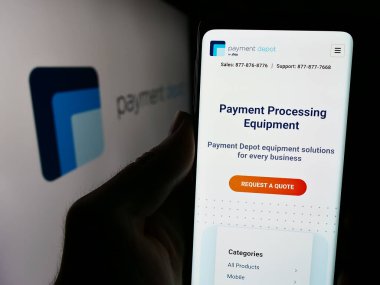 Stuttgart, Almanya - 05-27-2024: ABD kart işleme şirketi Payment Depot 'un (Stax Payments) logolu web sitesi ile cep telefonu tutan kişi. Telefon ekranının merkezine odaklan.