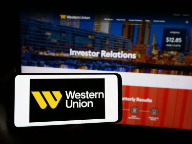 Stuttgart, Almanya - 05-27-2024: ABD 'li finans hizmetleri şirketi The Western Union Company' nin logosunun bulunduğu cep telefonu web sayfası önünde duruyor. Telefon ekranına odaklan.