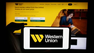 Stuttgart, Almanya - 05-27-2024: Amerikan finans hizmetleri şirketi The Western Union Company 'nin logosunun bulunduğu cep telefonu web sayfası önünde duruyor. Telefon ekranına odaklan.