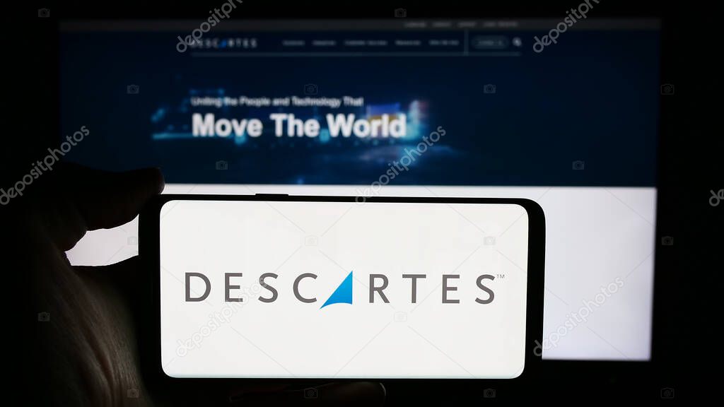 Stuttgart, Germany - 05-27-2024: Person holding cellphone with logo of Canadian company The Descartes Systems Group Inc. in front of business webpage. Focus on phone display.