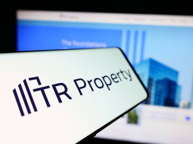 Stuttgart, Germany - 05-29-2024: Mobile phone with logo of British company TR Property Investment Trust plc in front of business website. Focus on left of phone display. clipart