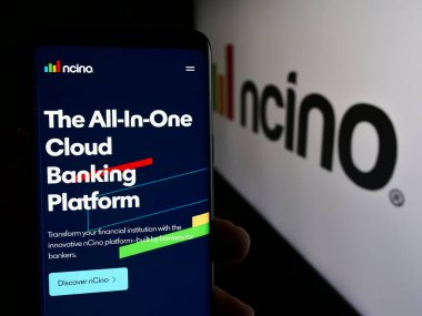 Stuttgart, Almanya - 05-29-2024: ABD 'li finans teknoloji şirketi nCino Inc.' in web sayfası ile logo önünde akıllı telefon tutan kişi. Telefon ekranının merkezine odaklan.