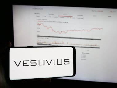 Stuttgart, Almanya - 05-30-2024: İngiliz mühendislik firması Vesuvius plc 'nin logosuna sahip cep telefonu sahibi kişi iş sayfasının önünde. Telefon ekranına odaklan.