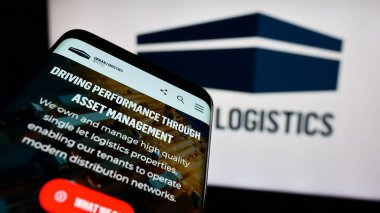 Stuttgart, Almanya - 05-30-2024: İngiliz emlak şirketi Urban Lojistik REIT plc 'nin web sayfası ile birlikte iş logosu önünde cep telefonu. Telefon ekranının sol üst kısmına odaklan.