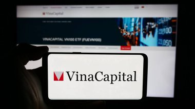 Stuttgart, Almanya - 05-30-2024: İş sayfası önünde Vietnamlı yatırım şirketi VinaCapital 'in logosuna sahip kişi. Telefon ekranına odaklan.