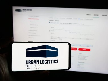 Stuttgart, Almanya - 05-30-2024: İngiliz emlak şirketi Urban Logistics REIT plc 'nin logosunun bulunduğu cep telefonu sahibi kişi web sayfasının önünde. Telefon ekranına odaklan.