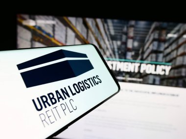 Stuttgart, Almanya - 05-30-2024: İngiliz emlak şirketi Urban Lojistik REIT plc 'nin logosunu taşıyan cep telefonu. Telefon ekranının merkez sağına odaklan.