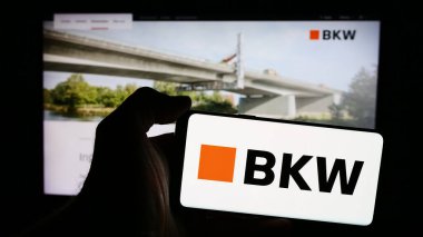 Stuttgart, Almanya - 05-31-2024: İsviçreli güç üreticisi firma BKW Energie AG 'nin logosunu taşıyan cep telefonu sahibi kişi iş sayfasının önünde. Telefon ekranına odaklan.