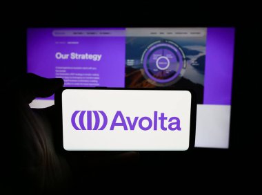 Stuttgart, Almanya - 05-31-2024: İsviçreli seyahat perakende şirketi Avolta AG 'nin logosuna sahip akıllı telefon sahibi kişi web sitesinin önünde. Telefon ekranına odaklan.