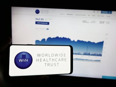 Stuttgart, Almanya - 05-31-2024: İngiliz şirketi Worldwide Healthcare Trust plc (WWH) 'nin logosunun bulunduğu cep telefonu web sayfasının önünde duruyor. Telefon ekranına odaklan.