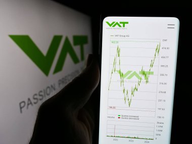 Stuttgart, Almanya - 05-31-2024: İsviçre vakum teknoloji şirketi KDV Group AG 'nin web sitesiyle logo önünde cep telefonu tutan kişi. Telefon ekranının merkezine odaklan.