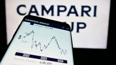 Stuttgart, Almanya - 06-01-2024: İtalyan ruhlar şirketi Davide Campari-Milano N.V. 'nin web sitesiyle birlikte iş logosu önünde cep telefonu. Telefon ekranının sol üst kısmına odaklan.
