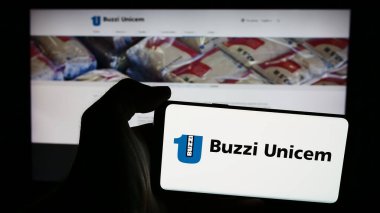 Stuttgart, Almanya - 06-01-2024: İtalyan inşaat malzemeleri şirketi Buzzi Unicem S.p.A. 'nın logosunun bulunduğu cep telefonu sahibi kişi web sayfasının önünde. Telefon ekranına odaklan.
