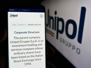 Stuttgart, Almanya - 06-01-2024: İtalyan finans hizmetleri şirketi Unipol Gruppo S.p.A. 'nın logolu web sayfası ile cep telefonu tutan kişi. Telefon ekranının merkezine odaklan.