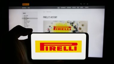 Stuttgart, Almanya - 06-01-2024: İtalyan lastik imalat şirketi Pirelli C. S.P.A. 'nın logosuna sahip cep telefonu sahibi kişi iş sayfasının önünde. Telefon ekranına odaklan.