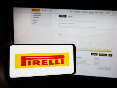Stuttgart, Almanya - 06-01-2024: İtalyan lastik imalat şirketi Pirelli C. SpA 'nın logosunu taşıyan cep telefonu sahibi kişi iş sayfasının önünde. Telefon ekranına odaklan.