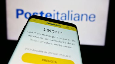 Stuttgart, Almanya - 06-01-2024: İtalyan posta hizmetleri şirketi Poste Italiane S.P.A. 'nın web sitesiyle birlikte iş logosu önünde cep telefonu. Telefon ekranının sol üst kısmına odaklan.
