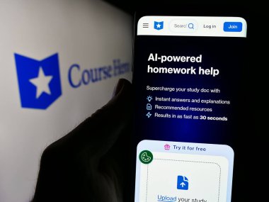 Stuttgart, Almanya - 06-01-2024: ABD eğitim teknoloji şirketi Course Hero 'nun logo önündeki web sayfası ile akıllı telefon sahibi kişi. Telefon ekranının merkezine odaklan.