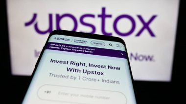 Stuttgart, Almanya - 06-03-2024: Ticaret platformu şirketi Upstox Securities Pvt. web sitesi ile akıllı telefon Ltd. İş logosu önünde. Telefon ekranının sol üst kısmına odaklan.