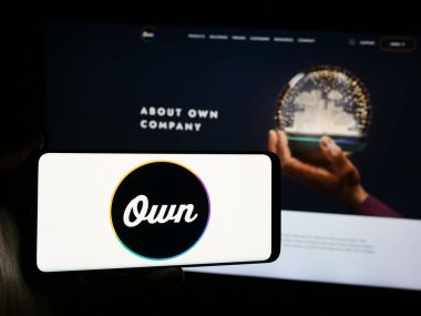 Stuttgart, Almanya - 06-03-2024: İnternet sitesi önünde üzerinde ABD veri platformu işletmesi (OwnData) logosu bulunan kişi. Telefon ekranına odaklan.