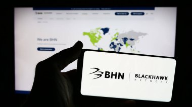 Stuttgart, Almanya - 06-03-2024: Web sitesi önünde ödeme çözümleri şirketi Blackhawk Network Holding Inc. 'nin logosuna sahip akıllı telefon sahibi kişi. Telefon ekranına odaklan.