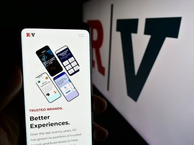 Stuttgart, Almanya - 06-03-2024: ABD 'li medya şirketi Red Ventures LLLC' nin web sayfası ile iş logosu önünde cep telefonu tutan kişi. Telefon ekranının merkezine odaklan.