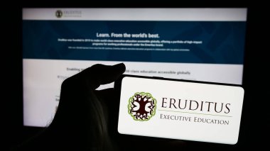 Stuttgart, Almanya - 03-06-2024: Singapur şirketi Eruditus Executive Education 'ın logosunu taşıyan cep telefonu sahibi şirket web sitesi önünde. Telefon ekranına odaklan.